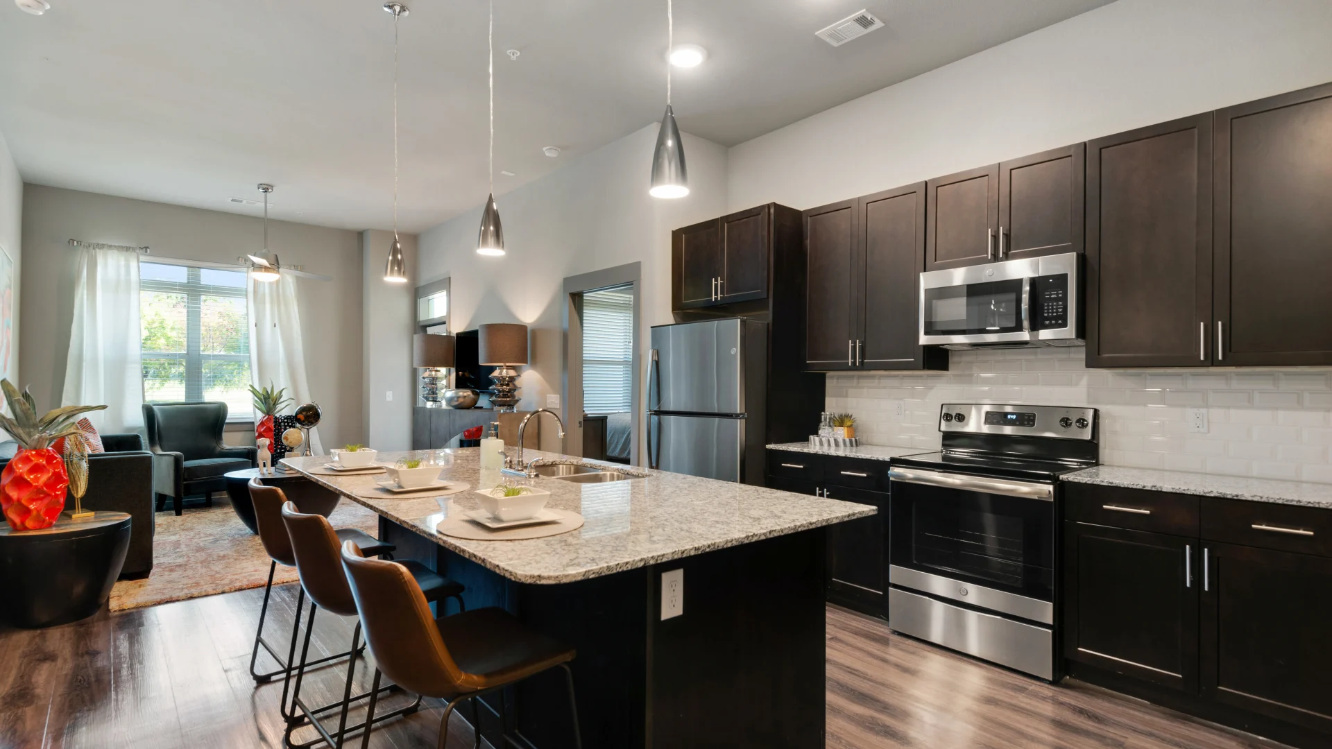 a kitchen with black cabinets and stainless steel appliances at The Discovery Park
