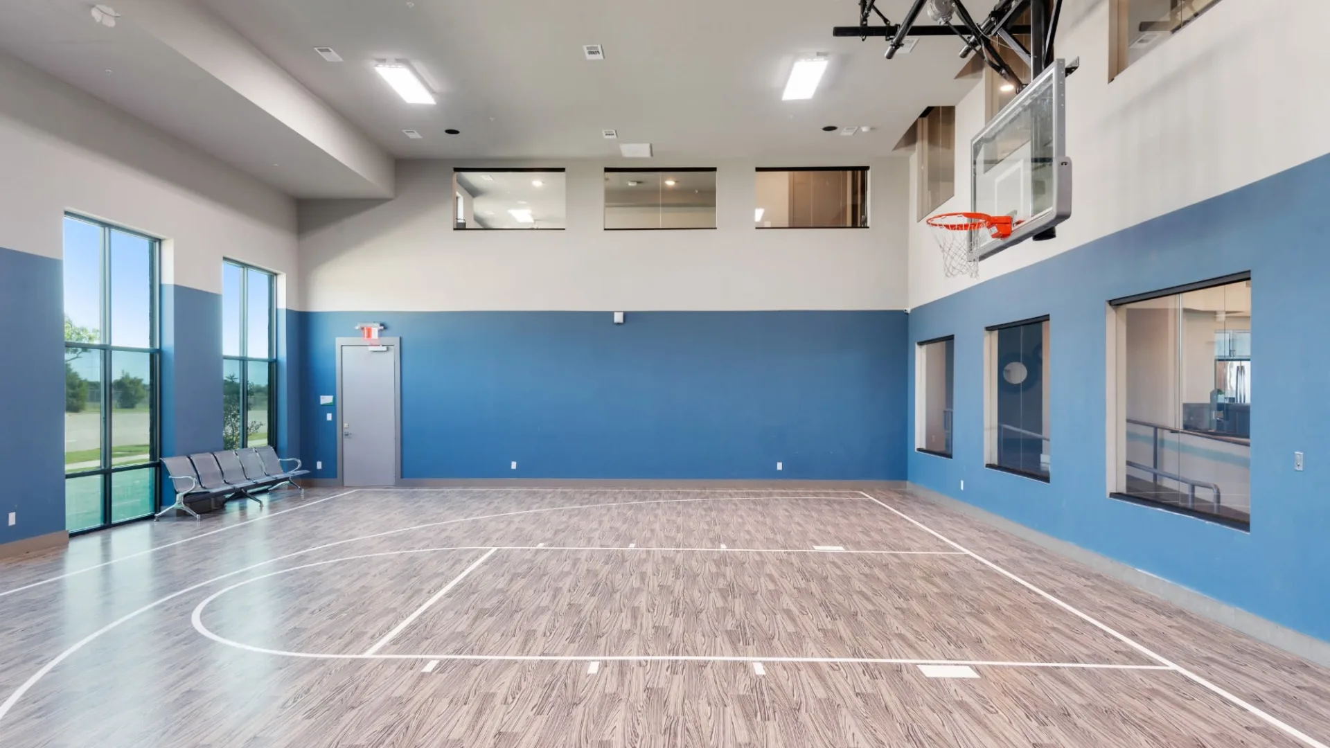 a basketball court inside a gym with blue walls at The Discovery Park