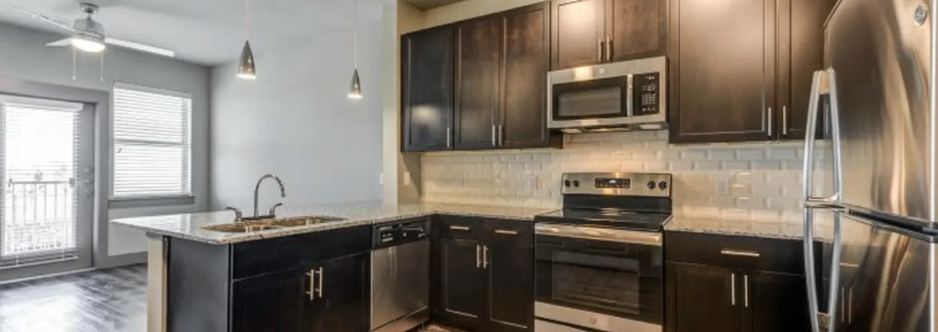 a kitchen with stainless steel appliances and dark wood cabinets at The Discovery Park