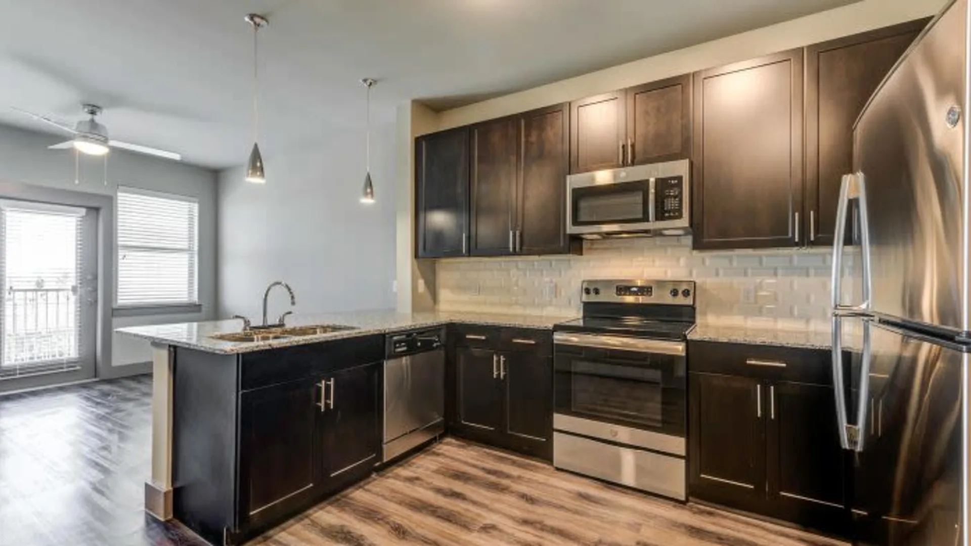 a kitchen with stainless steel appliances and dark wood cabinets at The Discovery Park