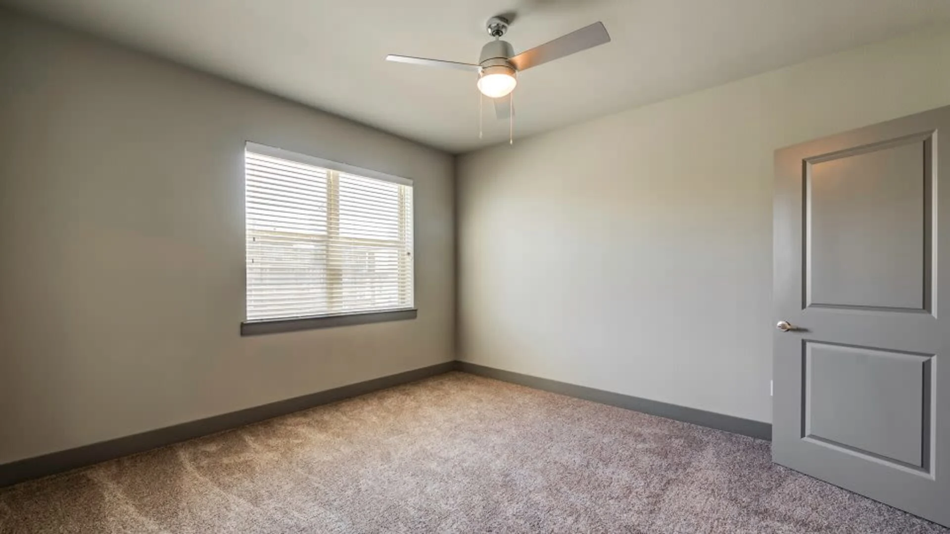 empty room with ceiling fan and carpet at The Discovery Park